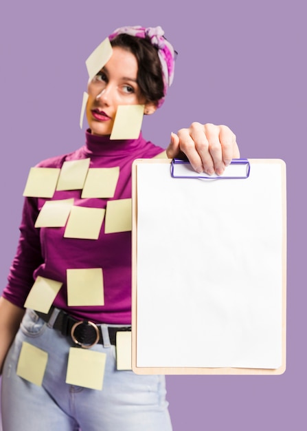 Woman with sticky notes on her holding a clipboard