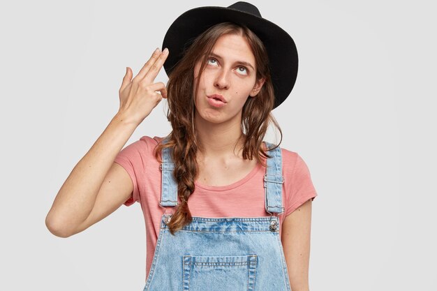 Woman with stylish black hat and overalls