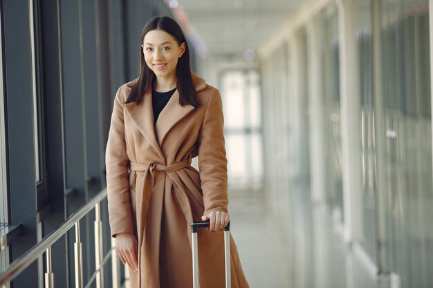 空港でスーツケースを持つ女性