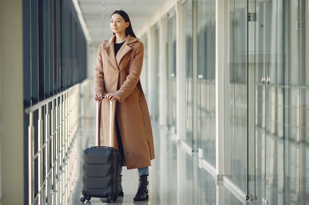 空港でスーツケースを持つ女性