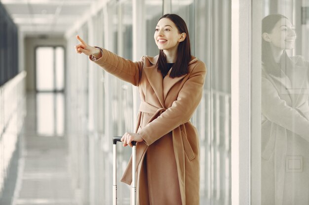 空港でスーツケースを持つ女性