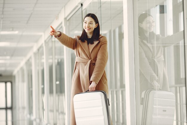 空港でスーツケースを持つ女性