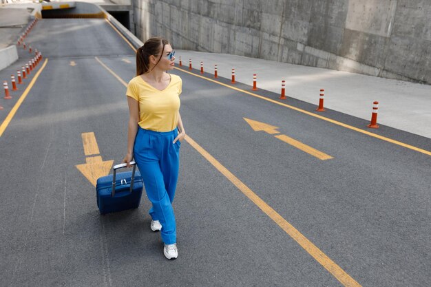 woman with suitcase moving on the road