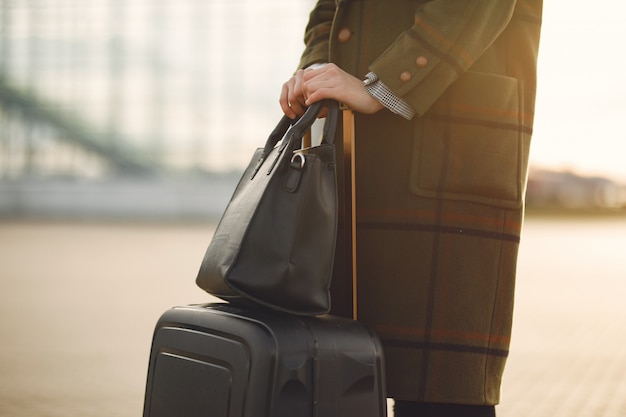 Woman with suitcase standing by the airport