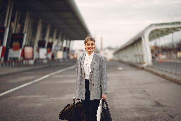 空港でスーツケース立っている女性