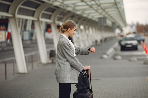 Foto gratuita donna con la valigia che fa una pausa l'aeroporto