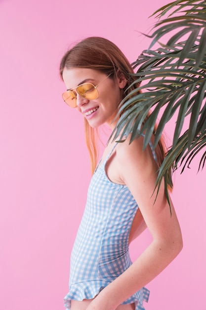 Woman with sunglasses in front of palm tree