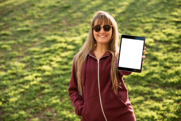 woman with sunglasses holding tablet