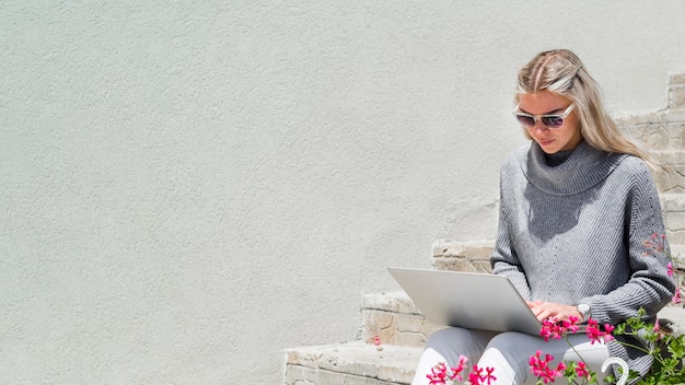 야외에서 노트북에서 일하는 선글라스와 여자