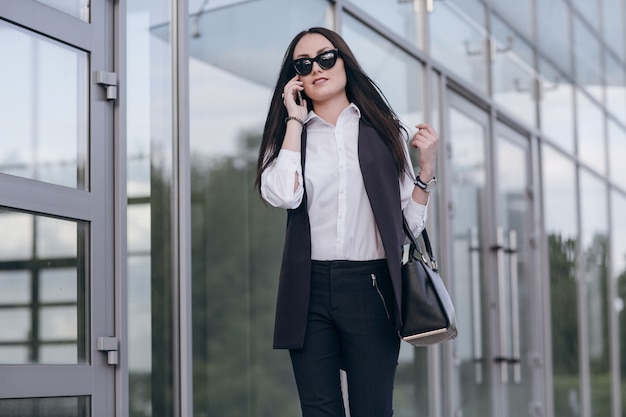 Donna con gli occhiali da sole che comunica sul telefono