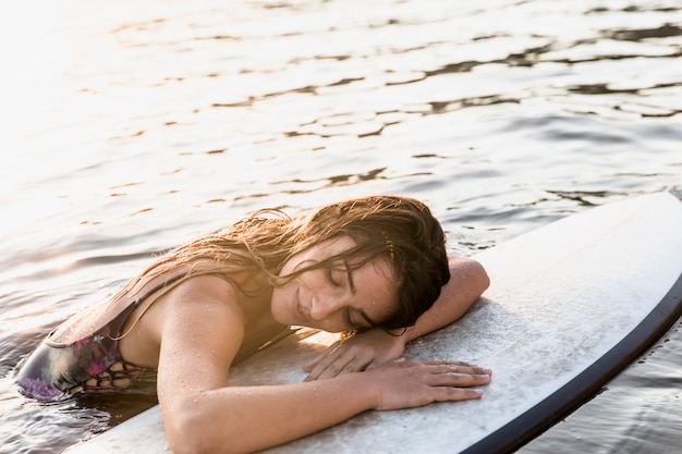 Foto gratuita donna con tavola da surf in spiaggia