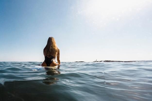 Donna con tavola da surf in acqua