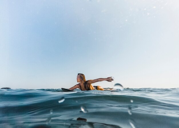 水中でサーフボードを持つ女性
