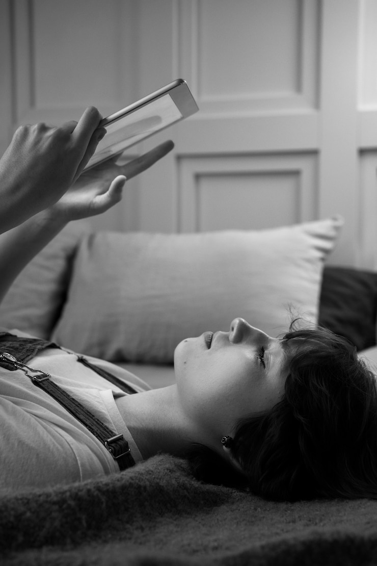 無料Photo ベッドの側面図でタブレットを持つ女性