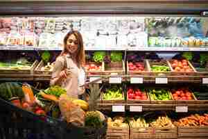 Free photo woman with tablet checking shopping cart to see if she has everything she needs for lunch