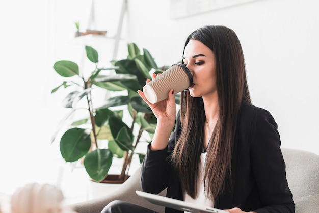 Woman with tablet drinking