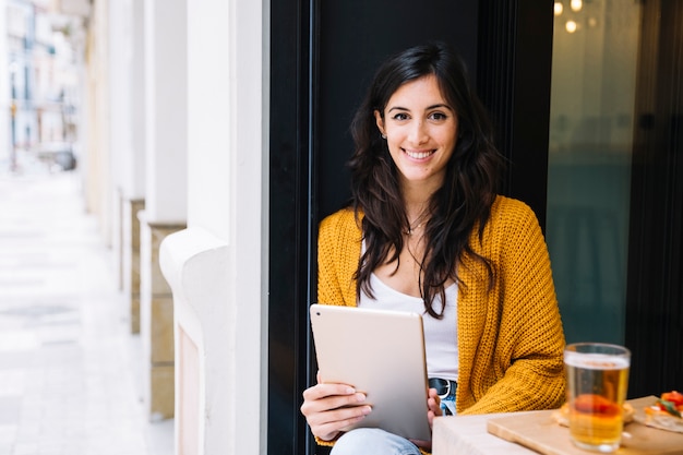 Woman with tablet at street cafe table