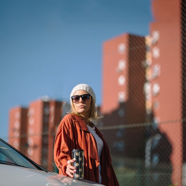 Woman with thermos near car