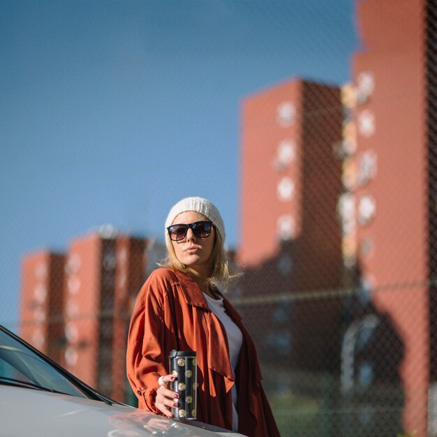 Woman with thermos near car