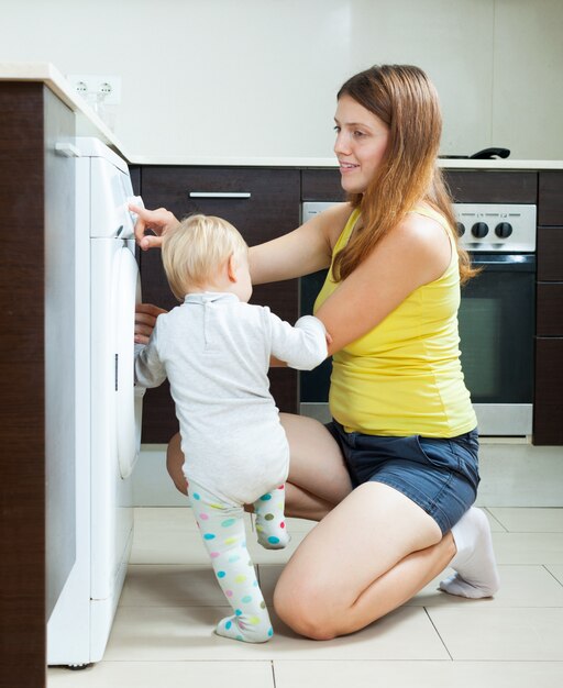 Woman with toddler using washing machine