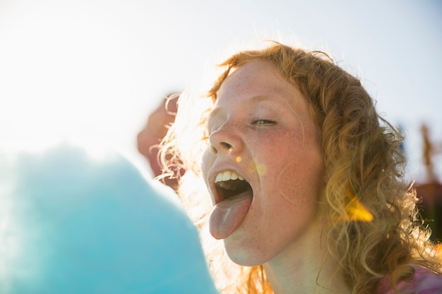 Woman with tongue out eating cotton candy