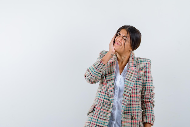 The woman with tootheache is putting her hand on cheek on white background