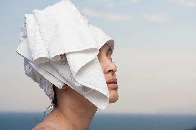 Женщина с полотенцем на голове, чтобы высушить волосы