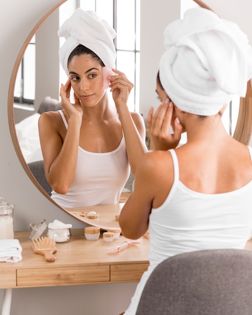 Woman with towel looking into the mirror