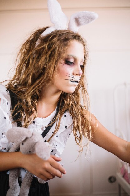 Woman with toy in hare face paint