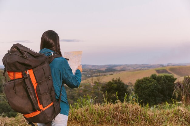 Woman with travel backpack looking in map