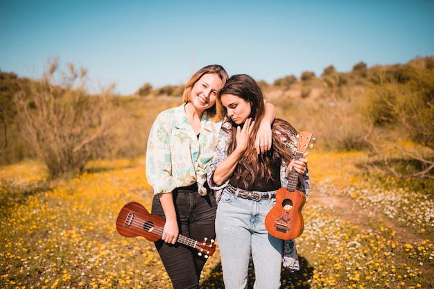 Woman with ukuleles embracing in field