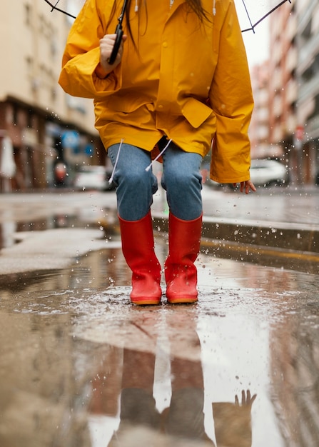 Бесплатное фото Женщина с зонтиком, стоя под дождем