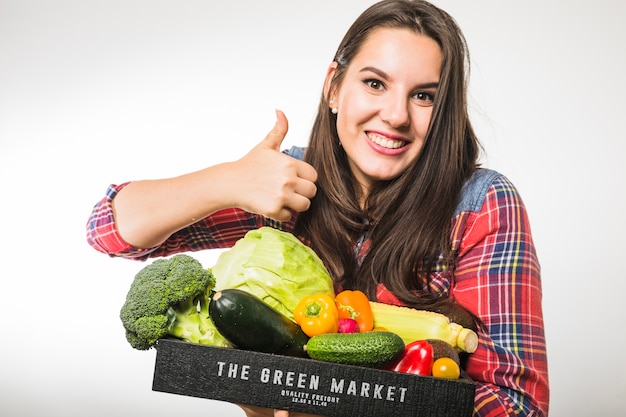 Woman with vegetables gesturing thumb up