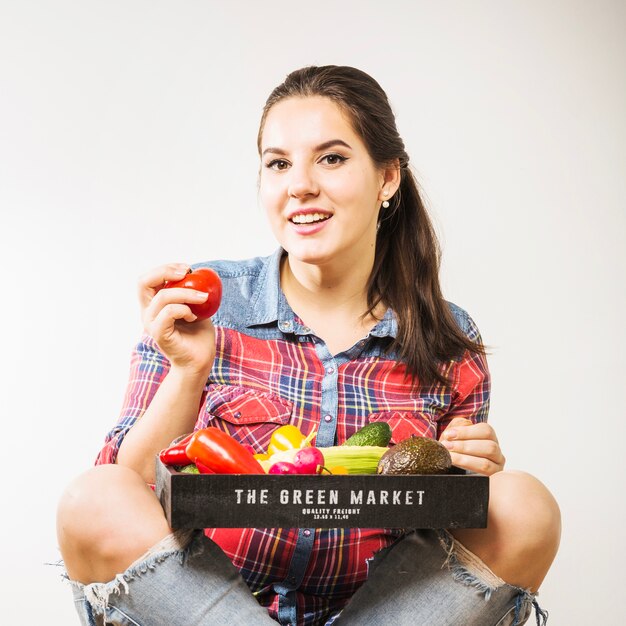 Woman with vegetables holding tomato