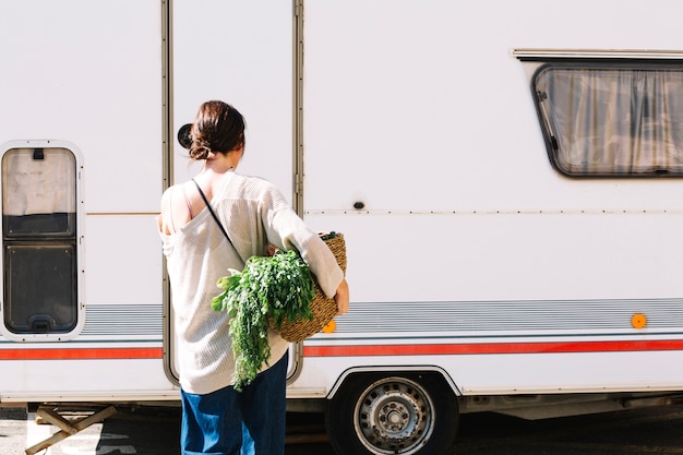 Женщина с овощами рядом с фургоном