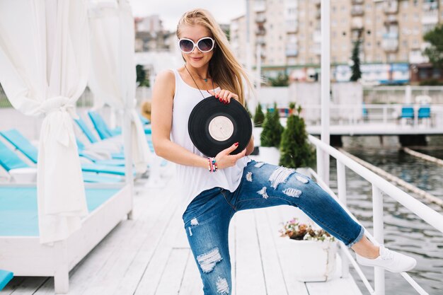 Woman with vinyl record on pier