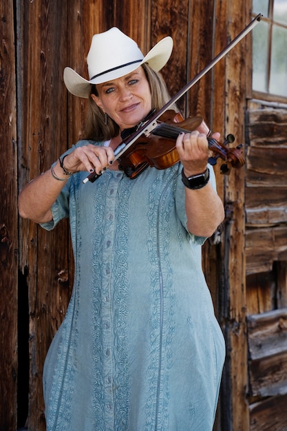 Бесплатное фото Женщина со скрипкой готовится к концерту кантри-музыки