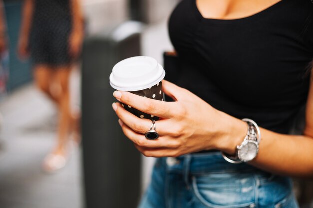 Woman with watch holding coffee cup