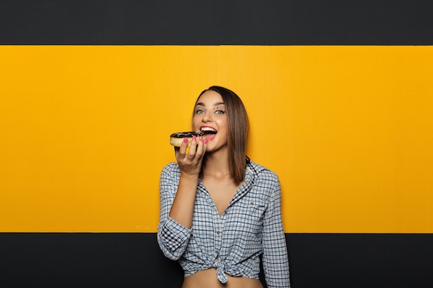 Woman with white bright smile eating tasty donut.