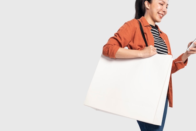 Free photo woman with a white shopping bag with design space