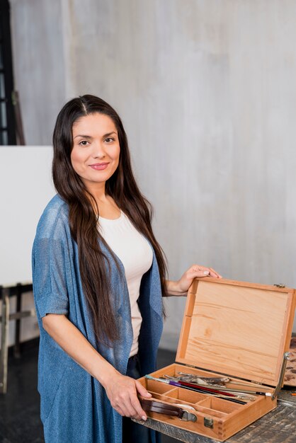 Woman with wooden box of paint materiales