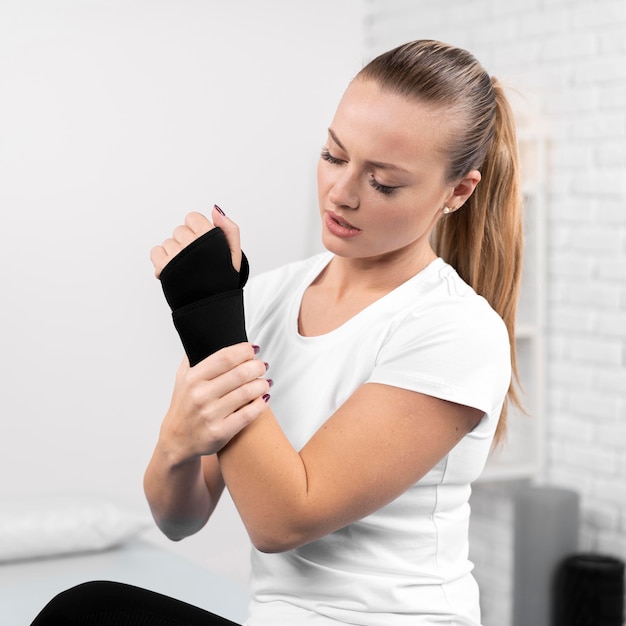 Free photo woman with wrapped wrist at physiotherapy