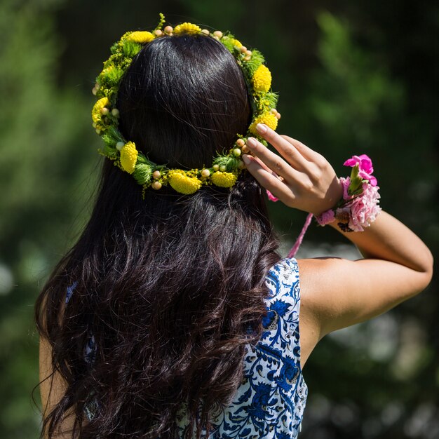 頭の中の黄色い花の花輪を持つ女性。