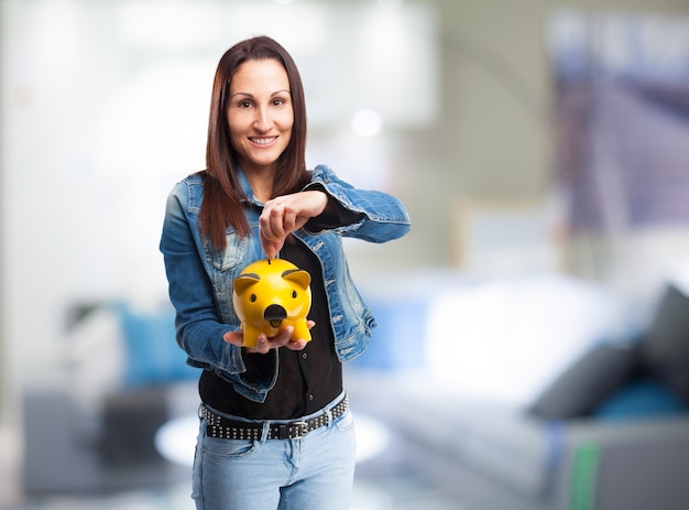 Woman with a yellow piggy bank