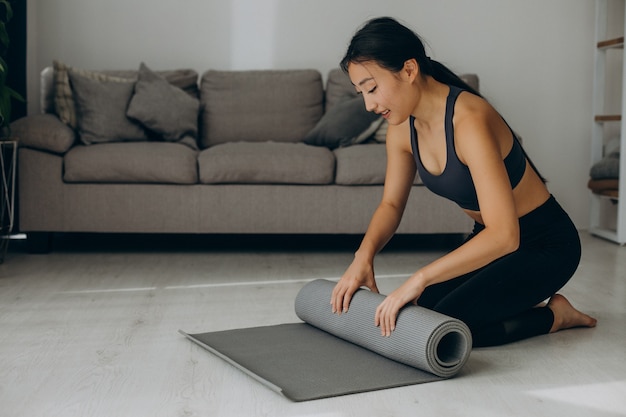 Woman with yoga mat at home