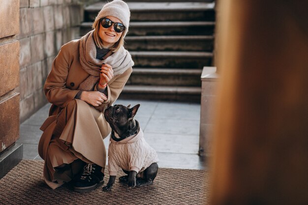 Woman withg her pet french bulldog walking out