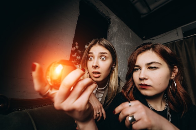 Cartomante di donna e donna con sfera di cristallo