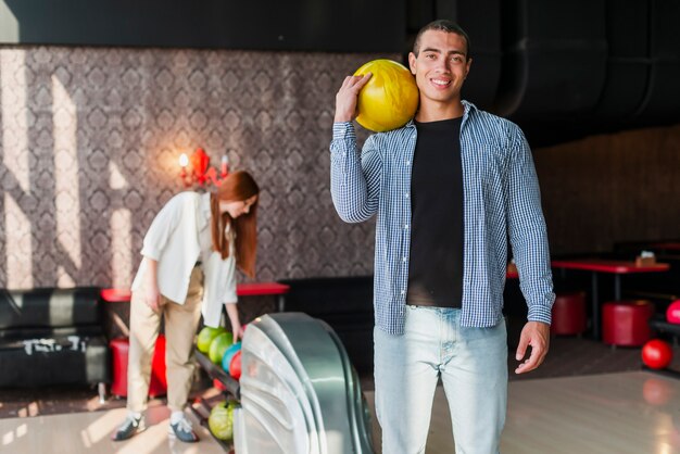 Woman and woman with bowling balls in a bowling club