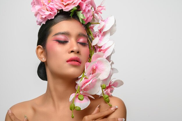 Woman wore pink makeup and beautifully decorated the flowers isolated on white