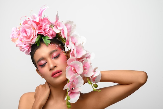 Woman wore pink makeup and beautifully decorated the flowers isolated on white